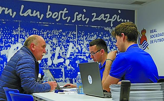 Uno de los abonados es atendido por personal de la Real, ayer en la oficina instalada en Arcco.