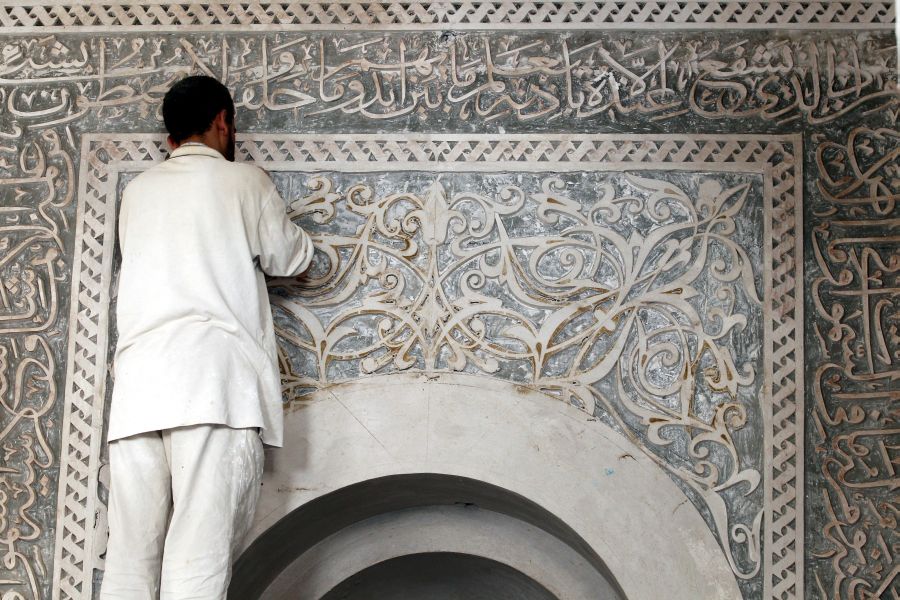 Un trabajador yemení realiza labores de restauración en una mezquita antes del Ramadán, en el casco antiguo de Saná (Yemen). 