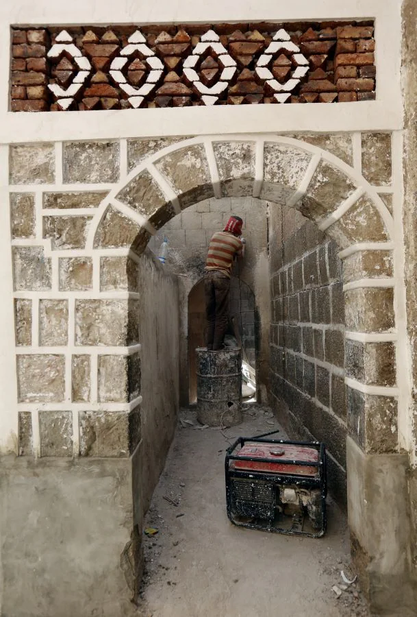 Un trabajador yemení realiza labores de restauración en una mezquita antes del Ramadán, en el casco antiguo de Saná (Yemen). 