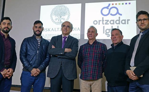 Ortzadar LGBT elkarteko eta Euskaltzaindiko ordezkariak, erdian Andres Urrutia euskaltzainburua eta Javier García Ortzadar LGBT elkarteko presidentea dituztela.