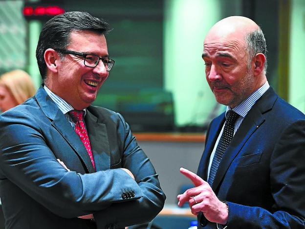 El ministro Román Escolano charla con el comisario económico, Pierre Moscovici.