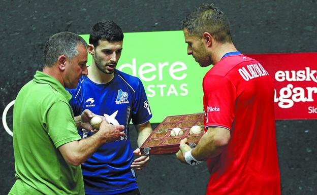 Martin Alustiza, seleccionador de material, recoge las pelotas de la final de manos de Jokin Altuna y Aimar Olaizola.