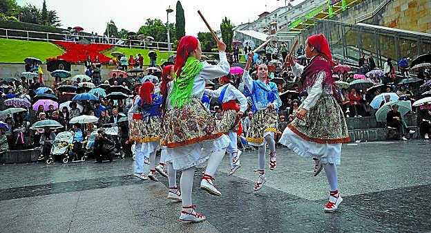 Euria. Eguraldiari aurre eginez ekin zioten dantzariek eta publikoak aterkiak zabalduta jarraitu zuen emanaldia. 
