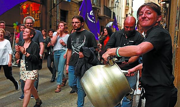 Participantes en la multitudinaria cacerolada de Donostia atraviesan las calles de la Parte Vieja con algunas banderas moradas.