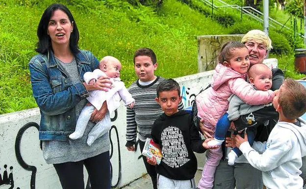 Susana Guerrero sostiene a la pequeña Ayala, y Raquel Bon coge en brazos a Paula y Rubén, rodeados por sus hermanos mayores Aimar, Javier y Adrián. 
