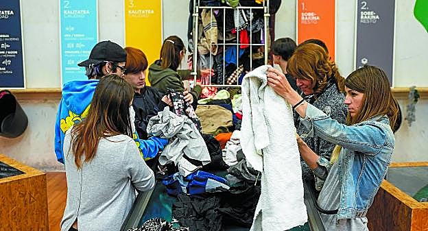 Alumnos de Diseño Gráfico de Salesianos de Urnieta clasifican la ropa usada en los talleres de Emaús. 
