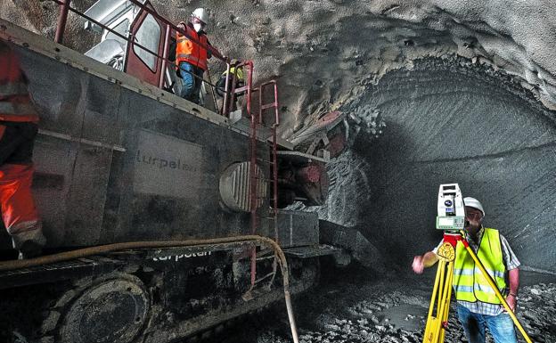 La rozadora excava el frente del túnel en Pío Baroja, mientras el topógrafo comprueba que avanza en la dirección exacta. 