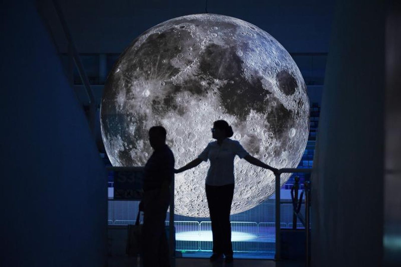 Un modelo de la Luna cuelga sobre la piscina olímpica en el Centro Aquático Nacional en Pekín, en China.