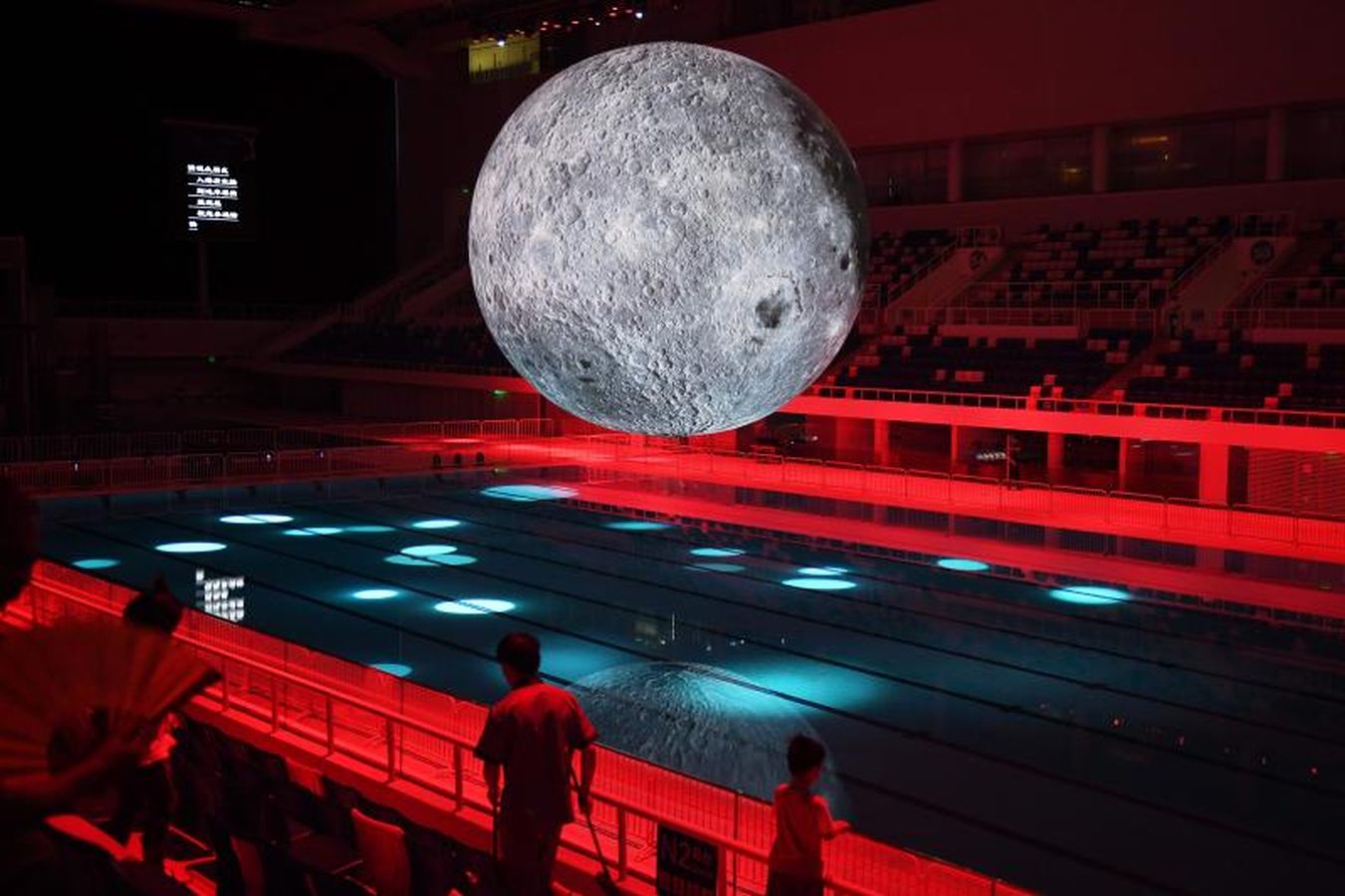 Un modelo de la Luna cuelga sobre la piscina olímpica en el Centro Aquático Nacional en Pekín, en China.