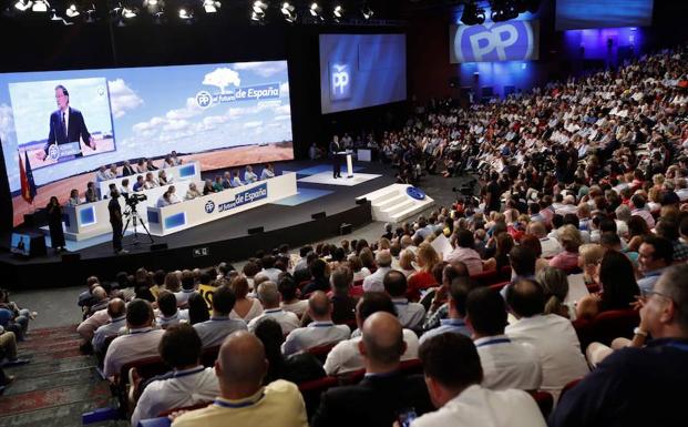 Varios asistentes al Congreso Nacional del Partido Popular atienden al discurso de Mariano Rajoy. 