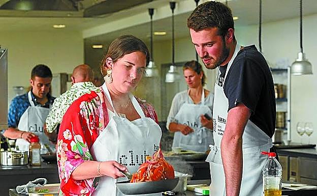 Un cocinero ayuda a una de las participantes en los cursos de verano del Basque Culinary Center. 