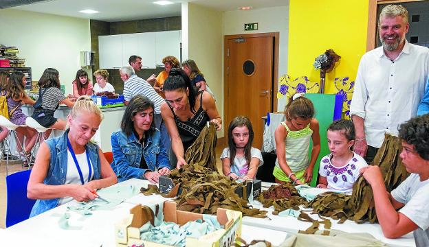 Residentes del centro de inclusión social y los niños del coro Easo comparten mesa y labores junto a Mafalda Saloio y Gorka Miranda. 