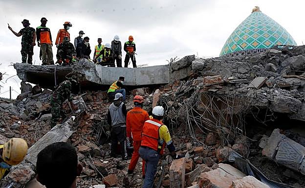 Miembros de los servicios de rescate buscan supervivientes entre los escombros de una mezquita.