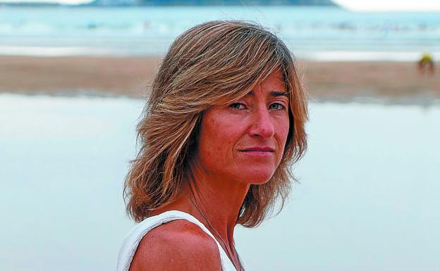 Pili Zabala en la playa de Zarautz, donde vive, con el Ratón de Getaria de fondo.