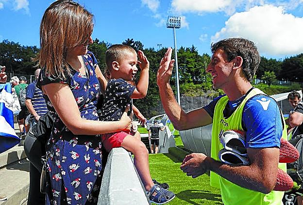 Oyarzabal choca la mano con un niño tras un entrenamiento en Zubieta.