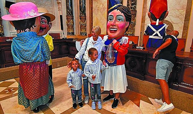 Una familia se retrata con los cabezudos en el Salón de Plenos.