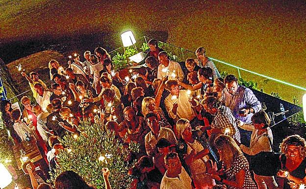 Los asistentes encienden las bengalas durante la fiesta en el Gu San Sebastián.