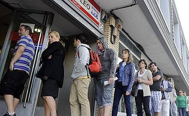 Varias personas esperando a las puertas de la oficina de empleo.