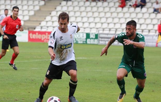 Urkizu avanza con la pelota con un rival del Leioa intentando tapar su carrera. 