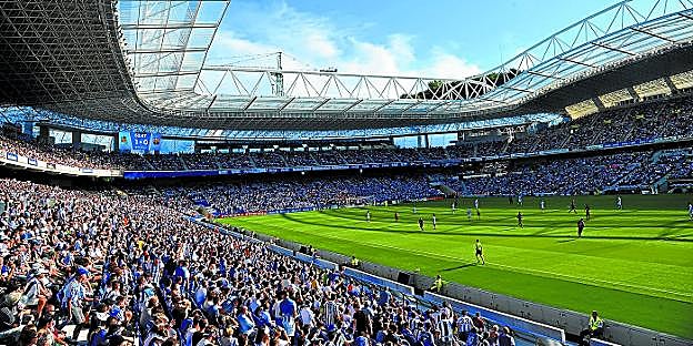 Panorámica de Anoeta con las gradas laterales acercadas al césped y la tribuna Sur terminada. En ese momento la Real ganaba 1-0, como se aprecia en el videomarcador. 