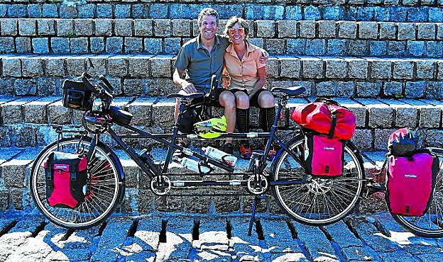 Iñaki y Garbiñe, junto al Peine del Viento con la bici tándem que se desmonta en tres piezas y acaban de estrenar. 