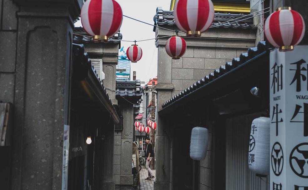 Un joven camina por una calle junto al canal de la ciudad de Otaru. 