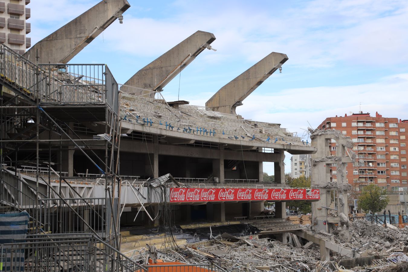 La demolición de la tribuna norte avanza a gran velocidad y se espera que la ejecución de esta fase de la obra esté concluida el próximo 15 de noviembre. La maquinaria se centra en desmontar los pórticos más cercanos a los pilares que sujetan la cercha.