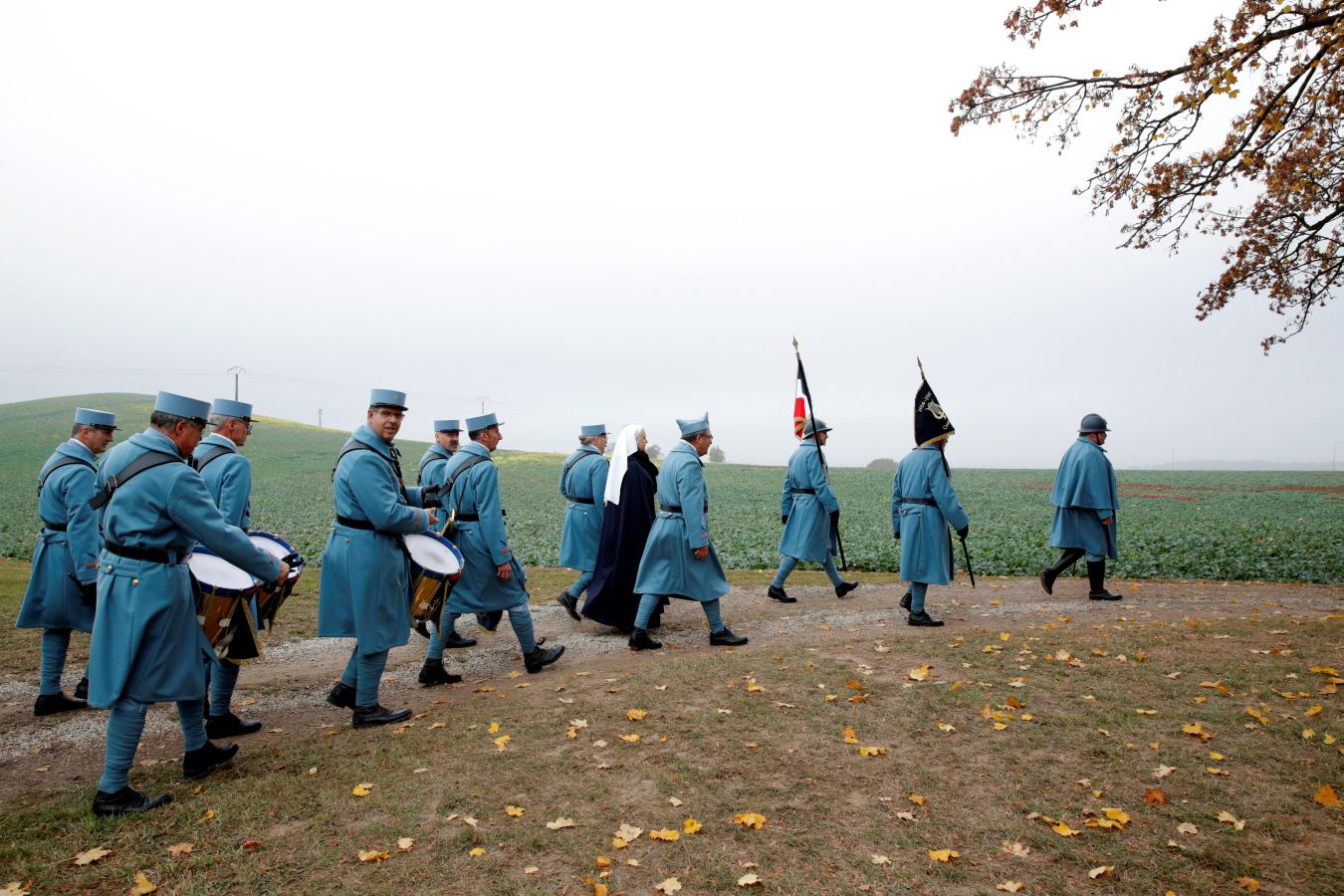 Hombres vestidos como soldados de la Primera Guerra Mundial y Emmanuel Macron en una ceremonia en memoria de los soldados caídos durante la Batalla de las Fronteras, en Morhangue. Macron inició una peregrinación conmemorativa por diferentes escenarios de la Primera Guerra Mundial, que acabará en París el próximo domingo, día en el que se cumplen cien años del armisticio.