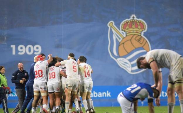 Los jugadores de la selección de Estados Unidos celebran su victoria ante Samoa, mientras un samoano es consolado por un estadounidense.