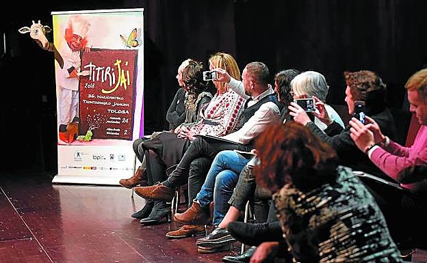 Organizadores y patrocinadores, viendo la actuación de 'Teatri Mobili' junto al cartel de Txitxi Orbegozo, este miércoles, tras la presentación. 
