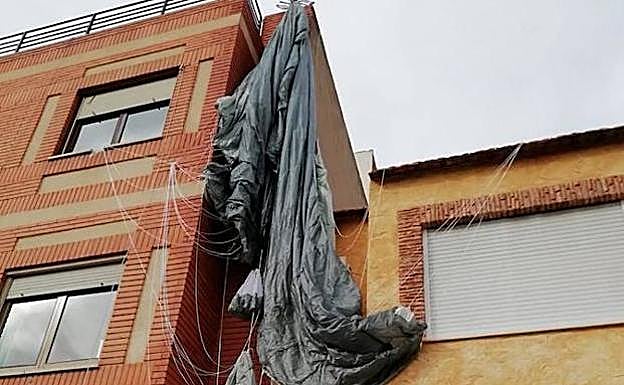El paracaidista enganchado en la antena de una vivienda. 