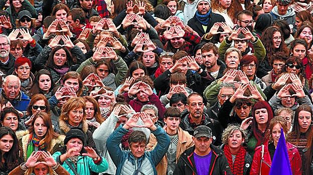 Los asistentes a la manifestación en Donostia, en su mayoría mujeres, unen sus manos para formar el símbolo feminista. 