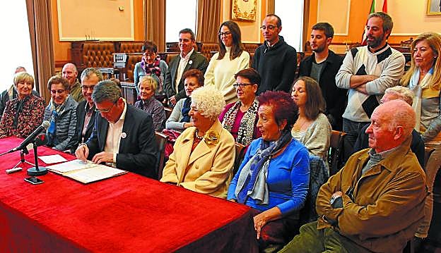 El alcalde firma el convenio bajo la mirada de representantes de la Comisión de Personas Mayores y de asociaciones de la ciudad, delegados del Gobierno municipal y portavoces y concejales de todos los grupos políticos del Ayuntamiento de Irun. 