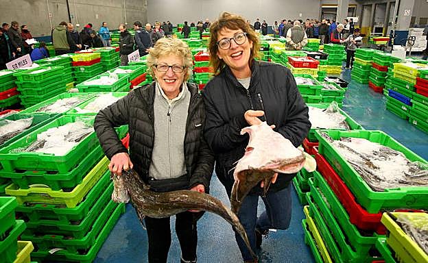 Imagen principal - Mari Carmen Alonso y su hija Ainhoa encontraron lo que buscaban así como Txomin de la Hoz, de Urretxu, que muestra un rape de 13 kilos. Las subastas de Imanol Zalakain fueron seguidas con gran interés por parte de los asistentes, así como las de la Cofradía de pesca