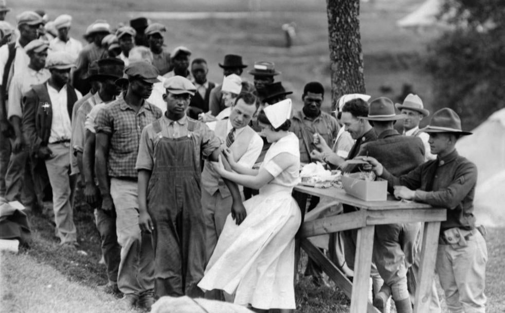 Decenas de campesinos negros voluntarios hacen cola ante las autoridades médicas en Tuskegee. 
