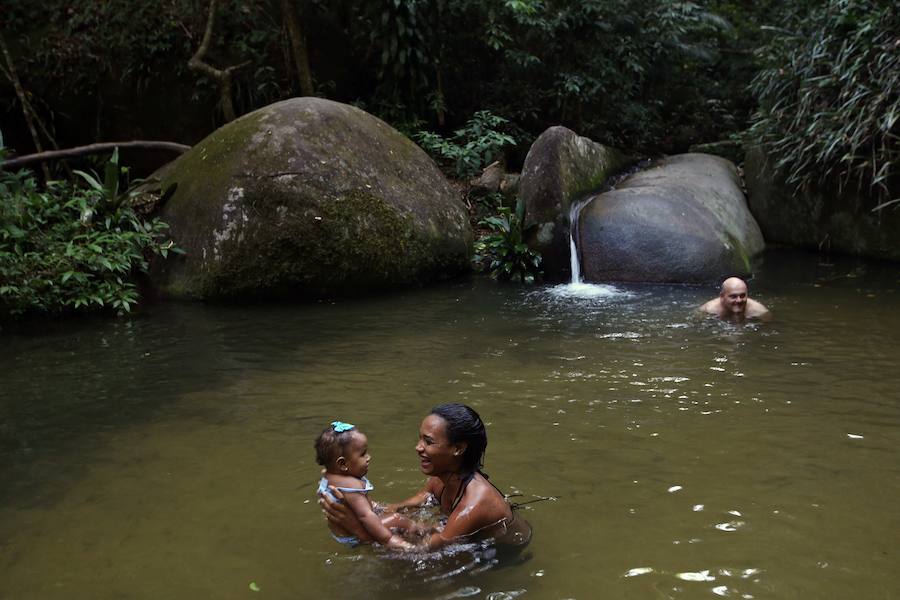 Ya ha comenzado ell verano austral. Pero las playas de Río de Janeiro ya están llenas de bañistas desde hace unas semanas. Y es que el calor aprieta. El martes los termómetros alcanzaron 40,7 grados en la zona oeste de la ciudad, en el que ha sido el día más caluroso en varios años, con una sensación térmica de 45 grados. El mar está calmado y apenas hay olas en las transparentes aguas. Las imágenes han sido tomadas en la Floresta de Tijuca, el bosque urbano más grande del mundo, y en los arenales del oeste de Río.