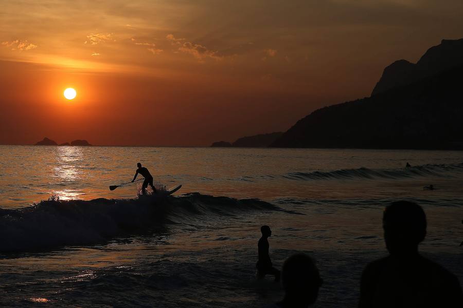 Ya ha comenzado ell verano austral. Pero las playas de Río de Janeiro ya están llenas de bañistas desde hace unas semanas. Y es que el calor aprieta. El martes los termómetros alcanzaron 40,7 grados en la zona oeste de la ciudad, en el que ha sido el día más caluroso en varios años, con una sensación térmica de 45 grados. El mar está calmado y apenas hay olas en las transparentes aguas. Las imágenes han sido tomadas en la Floresta de Tijuca, el bosque urbano más grande del mundo, y en los arenales del oeste de Río.