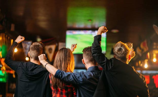 Aficionados viendo un partido en un bar. 