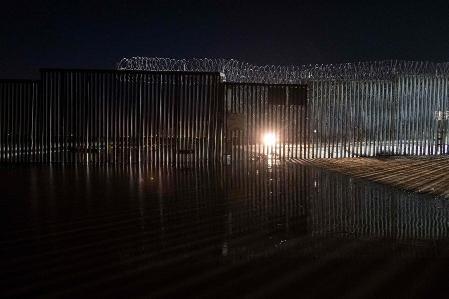 La gente camina cerca de la valla fronteriza entre México y Estados Unidos en Playas de Tijuana, México. El presidente Donald Trump advirtió el miércoles pasado que el gobierno federal de los EE. UU. se mantiene firme en su deseo de reforzar el muro fronterizo con México.