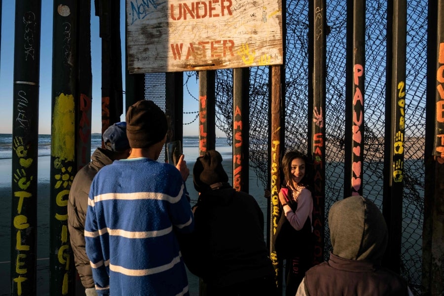 La gente camina cerca de la valla fronteriza entre México y Estados Unidos en Playas de Tijuana, México. El presidente Donald Trump advirtió el miércoles pasado que el gobierno federal de los EE. UU. se mantiene firme en su deseo de reforzar el muro fronterizo con México.