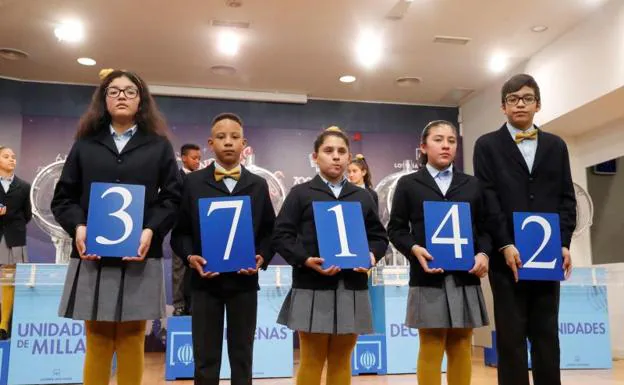 Los niños de San Ildefonso muestran el 37.142, agraciado con el primer premio del sorteo de la lotería de El Niño. 