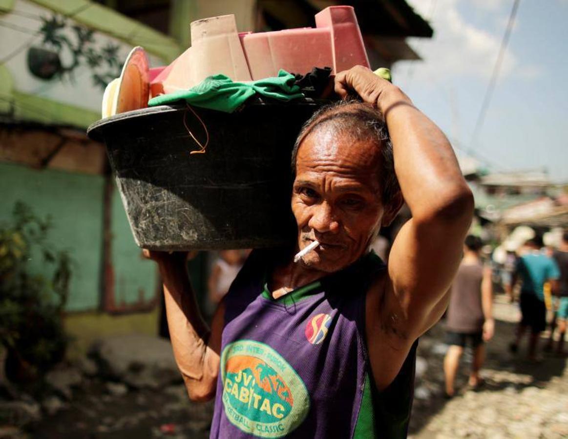 Residentes se afanan por apagar las llamas durante el incendio originado en un barrio de chabolas de Manila, en Filipinas, hoy, 11 de enero de 2019. El incendio destrozó las viviendas de al menos 100 familias pobres.