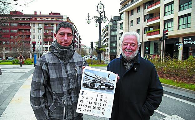 Ángel Gete y su hijo Ion posan con un calendario de Patxatxa Taldea, ante un emblema del barrio, la farola de Venta Berri.