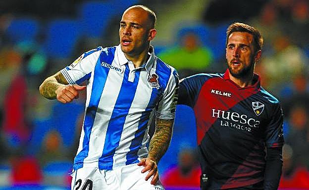 Sandro intenta ganarle la posición a Miramón en el partido de ayer entre la Real y el Huesca en Anoeta.