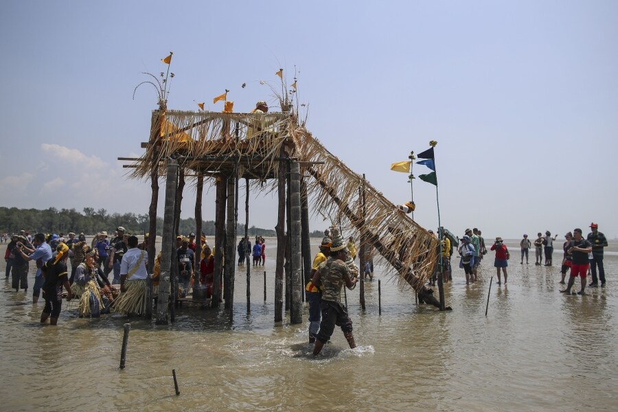 Los miembros de la tribu de Mah Meri, indígenas de Malasia, usan una máscara tradicional antes de iniciar el ritual «Puja Pantai», como gesto de agradecimiento que reza a los espíritus de los mares en Pulau Carey, a las afueras de Kuala Lumpur. 