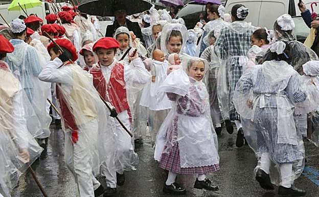 Protegidos con abrigos de plástico, los integrantes más jóvenes de la comparsa no soltaron sus palos y muñecas para bailar 