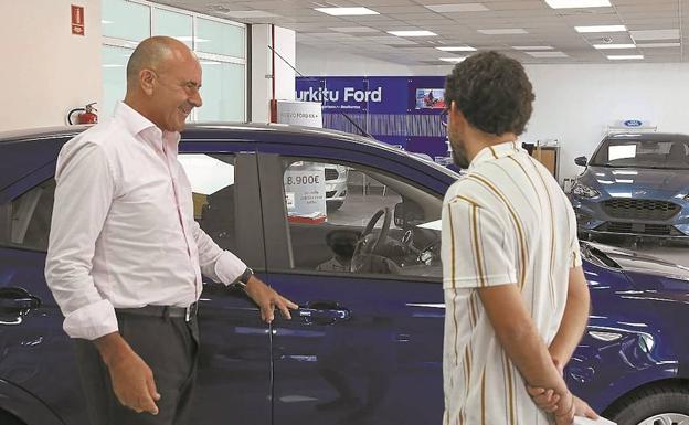 Un vendedor muestra un vehículo a un posible comprador en un concesionario de Oiartzun.