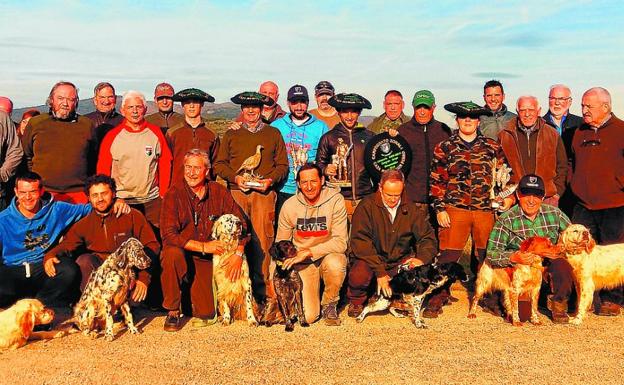 Los participantes del zonal de Donostialdea posan con las txapelas, los trofeos y sus perros en el coto La Valdorba. 