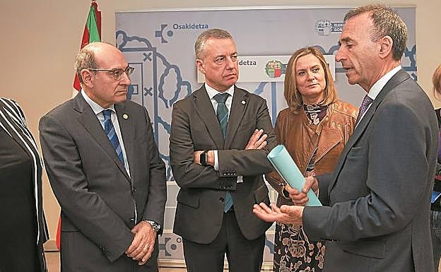 Jon Darpón e Iñigo Urkullu atienden las explicaciones del director del centro de salud de Retuerto. 