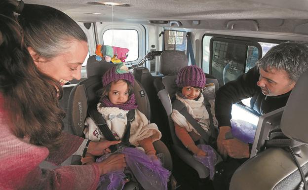 Aitziber y Jesús Mari ponen los cinturones de seguridad a sus hijas Intza y Aizpea antes de arrancar el coche.